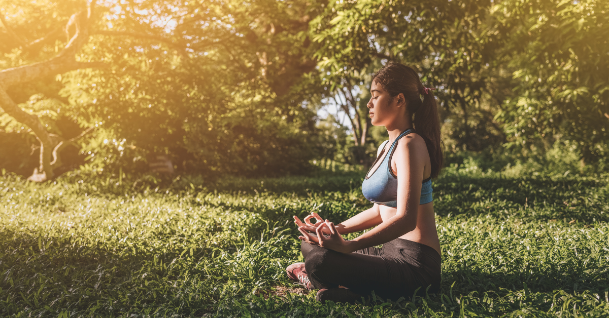 young woman meditating on the grass for reset mind